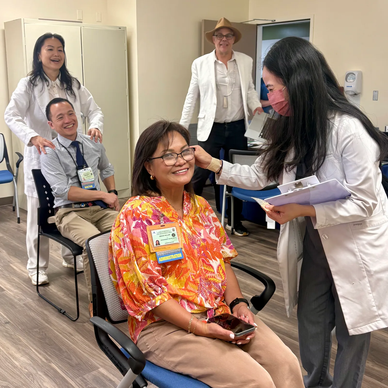 Wellness practitioners providing hands-on care to seated participants.